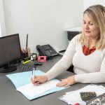 Kobieta księgowa przy biurku pracująca w swoim biurze