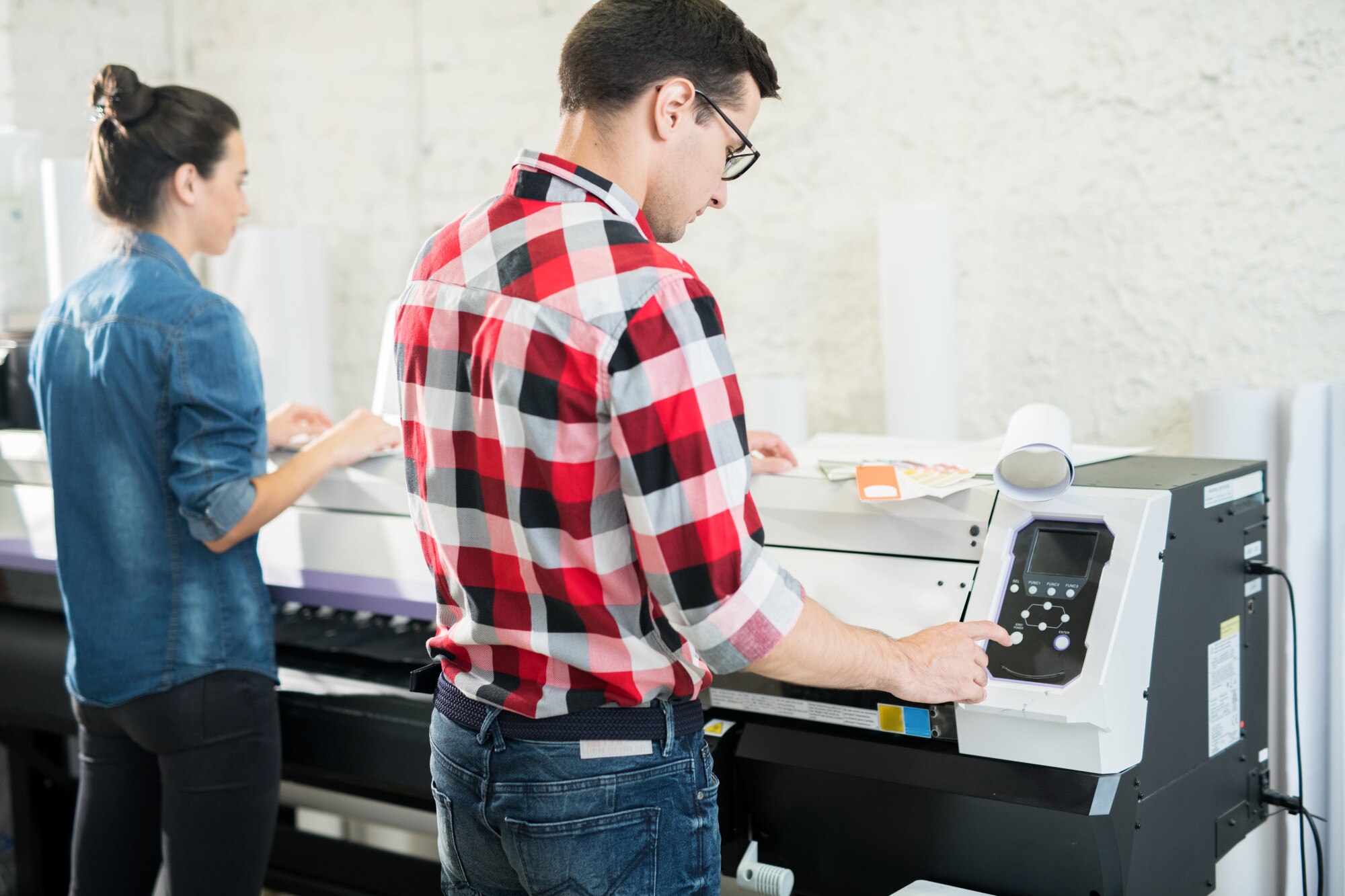 Mężczyzna i kobieta za pomocą sprzętu drukarskiego