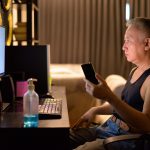 Dojrzały Japoński mężczyzna używa telefon podczas gdy pracujący od domu
